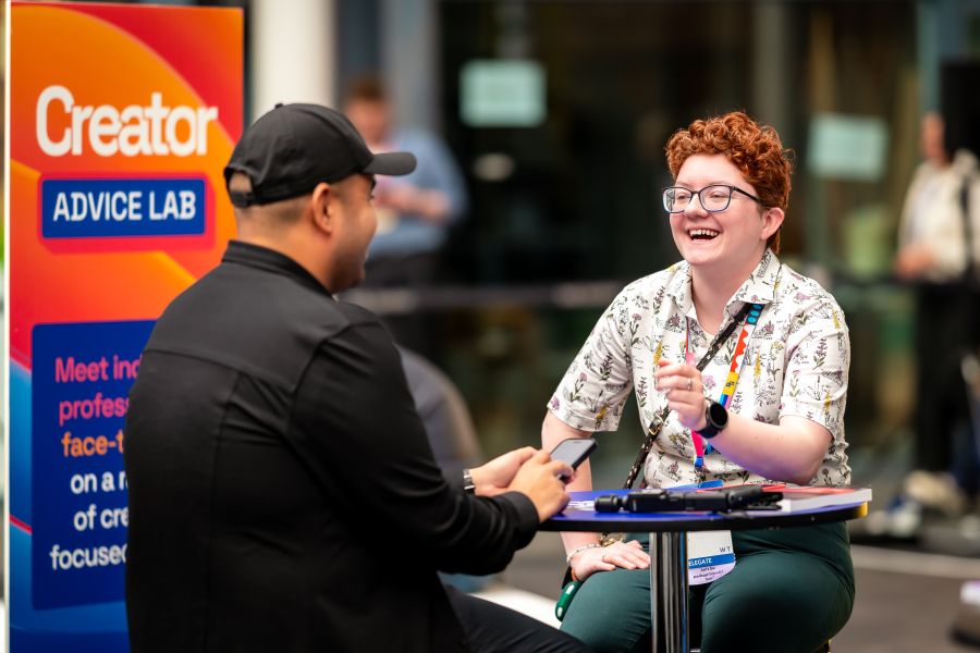 Two people talking and smiling at the Creator Advice Lab.