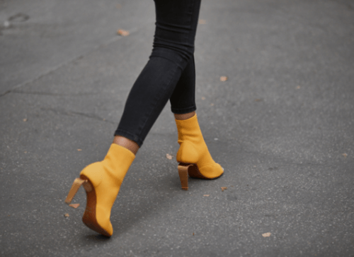 Yellow high-heeled boots walking on road