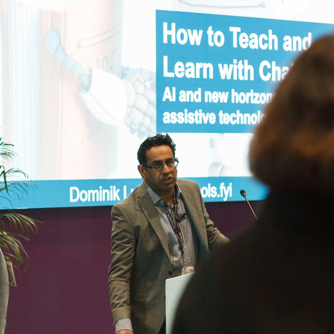 Mel Gomes presenting in front of screen