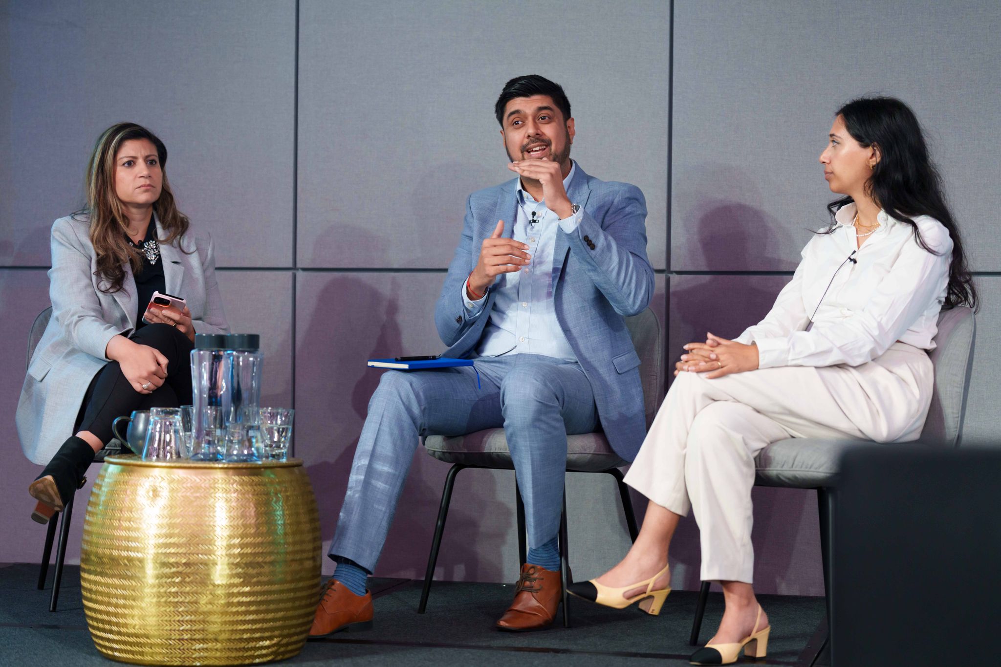 Panel of experts sitting on a stage with audience listening