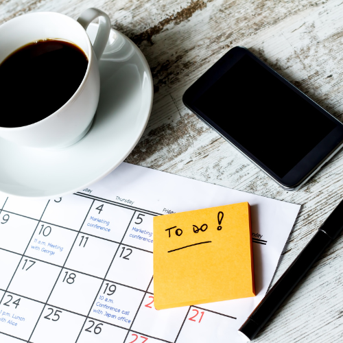 A desk with a coffee and a computer