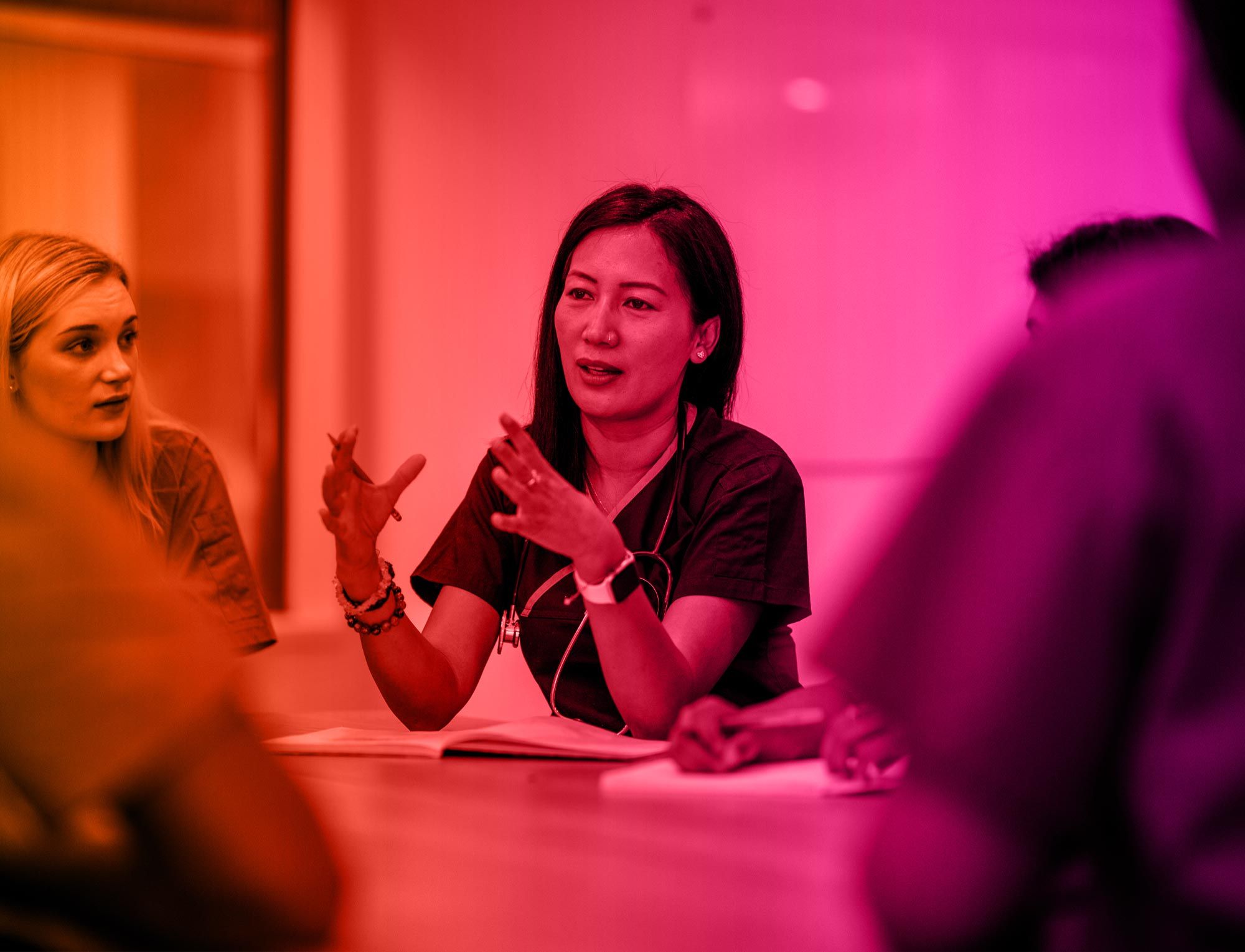 Lady at boardroom table chairing a discussion