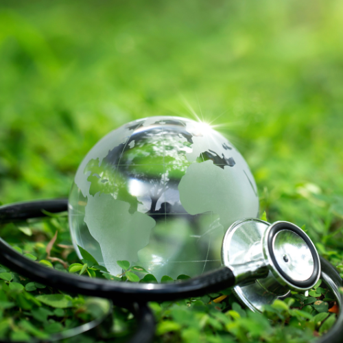 Map of the world on a round glass ball sitting on the grass with a stethoscope 