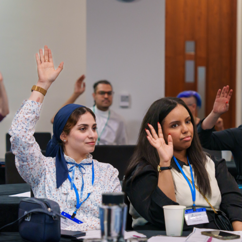 Ladies raising their hands at a conference