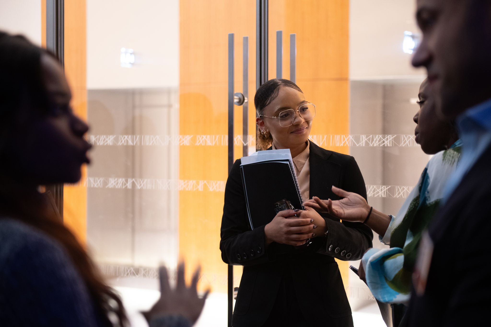 A woman holding a document, standing with colleagues