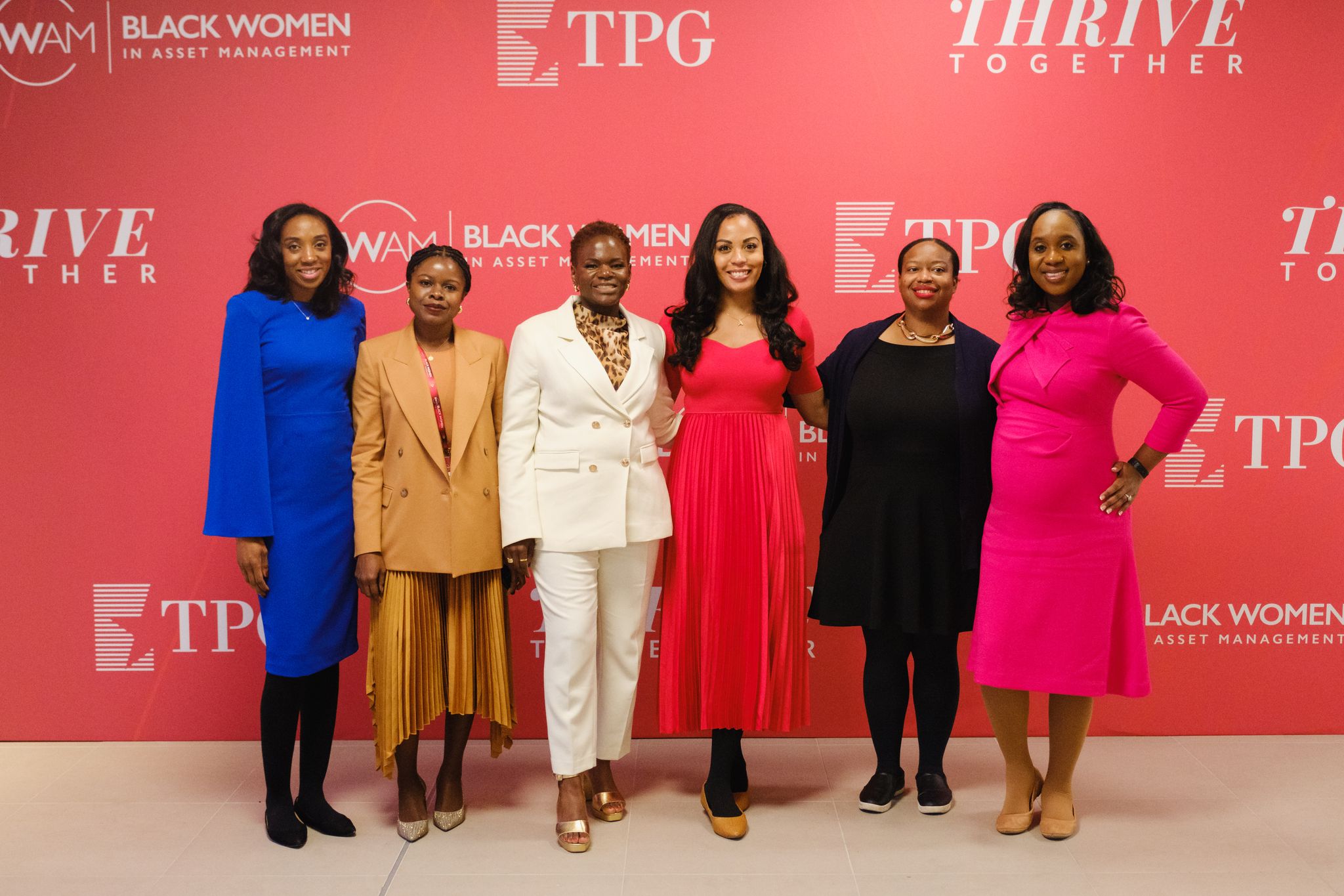A group of women standing in front of the BWAM conference backdrop. 