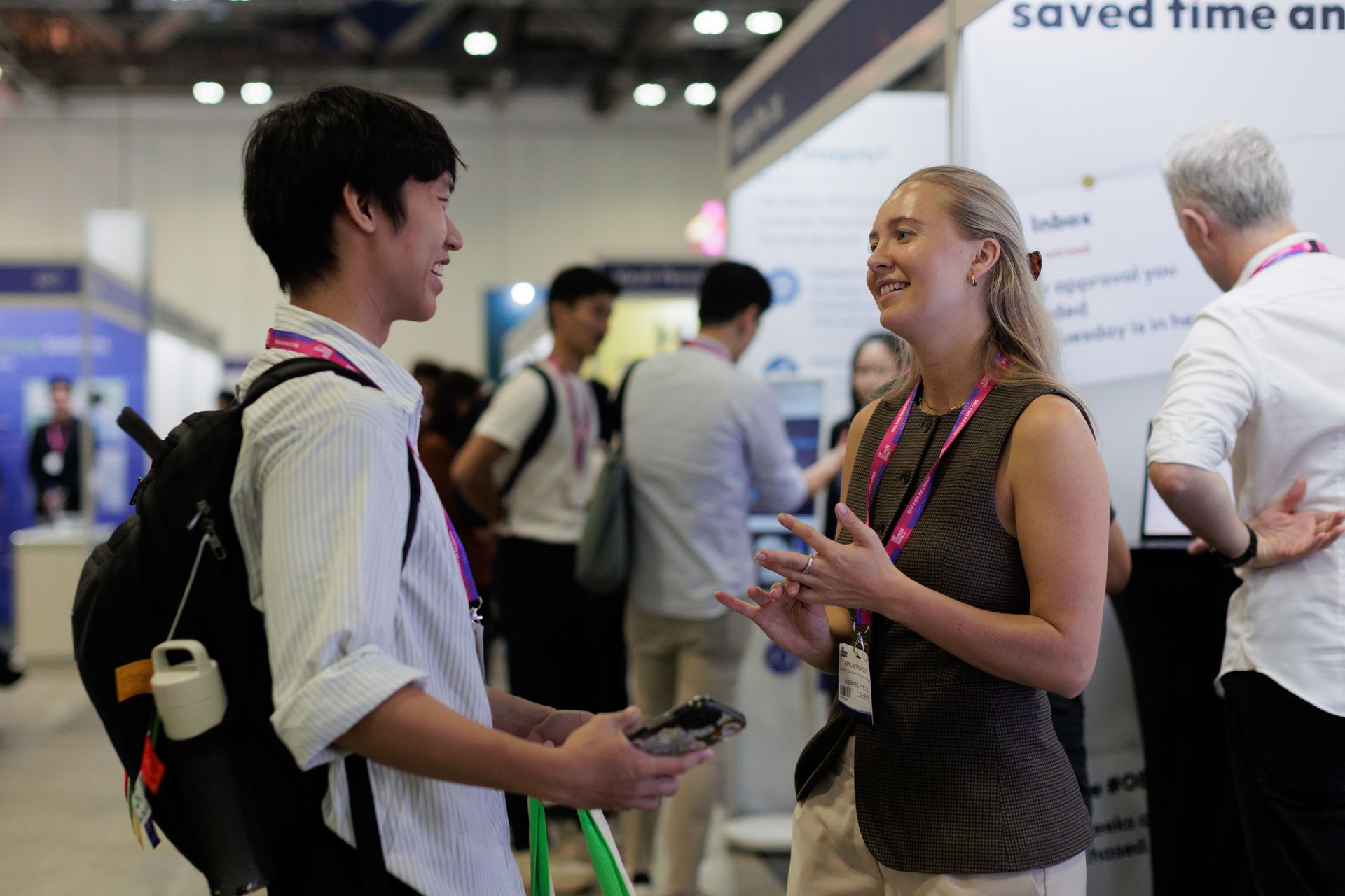 Professionals networking and discussing ideas at a business expo, exchanging insights during a conference in Singapore