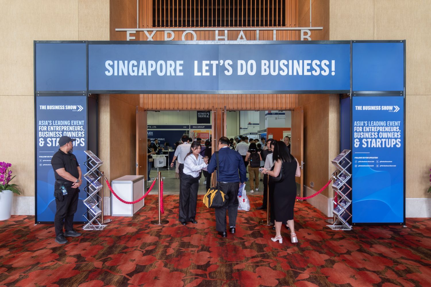 “Entrance to The Business Show Asia in Singapore, with attendees entering under a ‘Let’s Do Business’ banner”