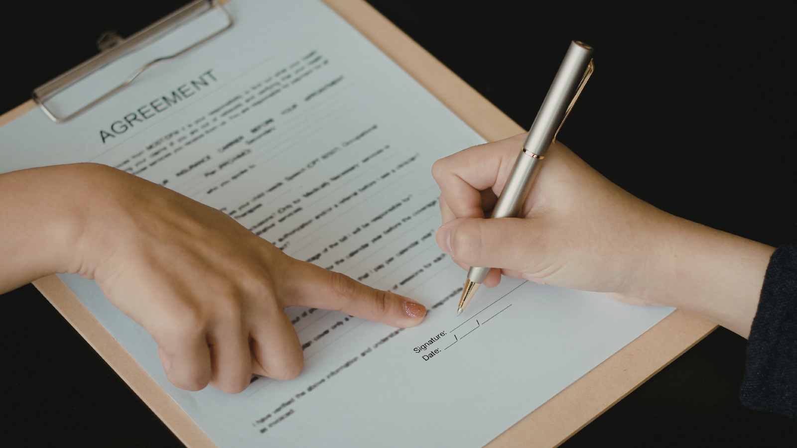 A picture of two people signing an agreement