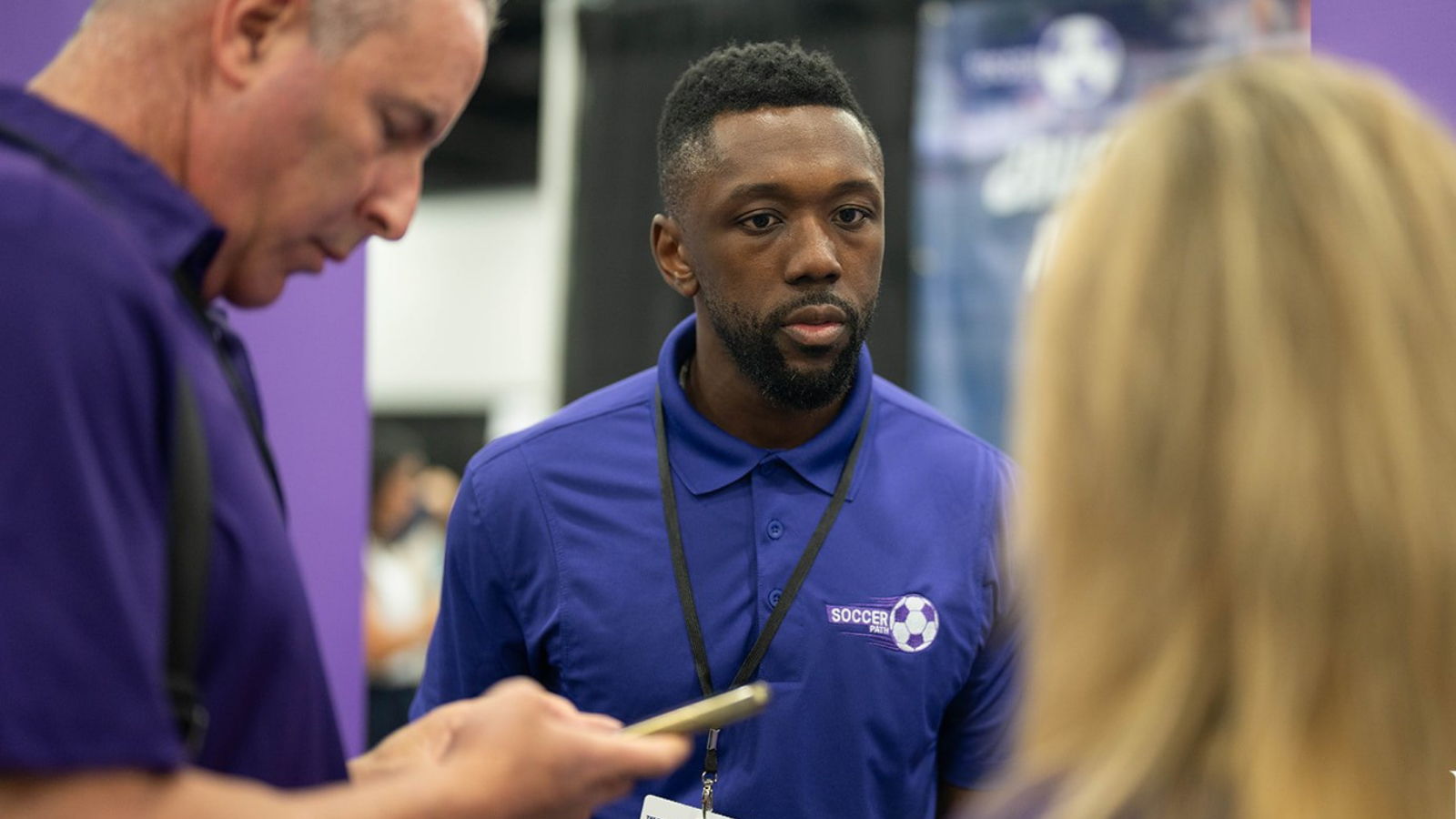 Attendees speaking with an exhibitor at The Business Show Miami, focused on networking, partnerships, and business growth opportunities.