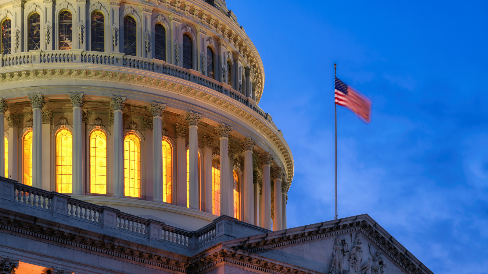 A picture of Capitol hill in the evening. An American flag flutters in the wind