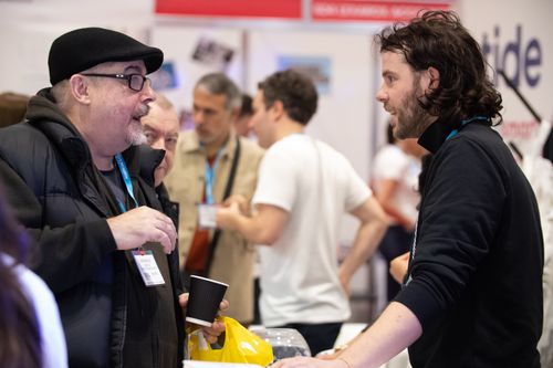 Mid-way Conversation of Male Visitor and Male Exhibitor