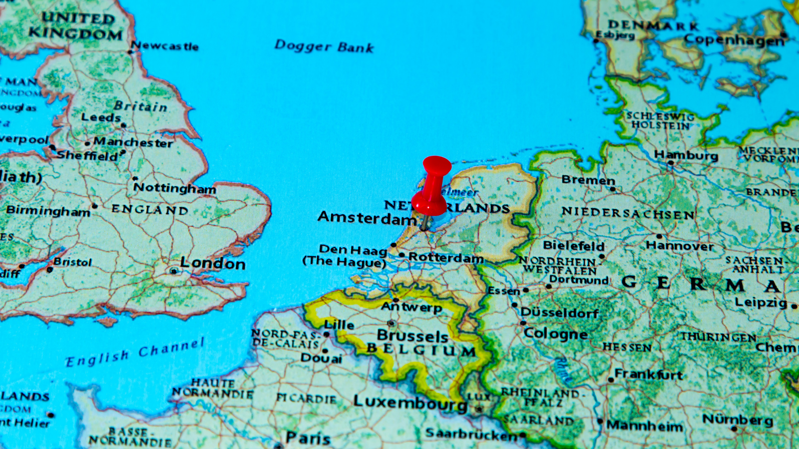 Map of Europe with a red pin marking Amsterdam in the Netherlands, showing the proximity of Amsterdam to EU and UK markets