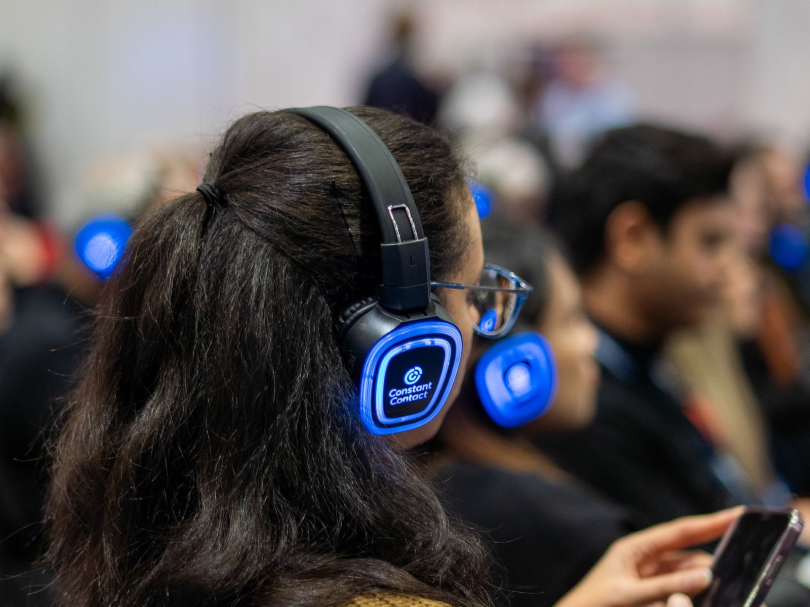 An image of a woman wearing a set light up headphones attending an interactive masterclass for The Business Show Amsterdam