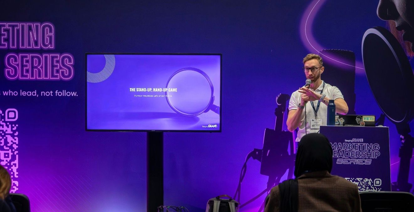 Speaker standing next to screen.