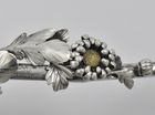 A Japanese silver Meiji period (1868 -1912) serving spoon decorated with chrysanthemums inlaid with gold, having an asymmetrical twig handle adorned with foliage and buds, by Sadajiro (of) Musashiya.