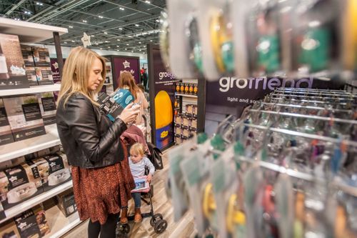 Woman looking at Tommee Tippee products on display.