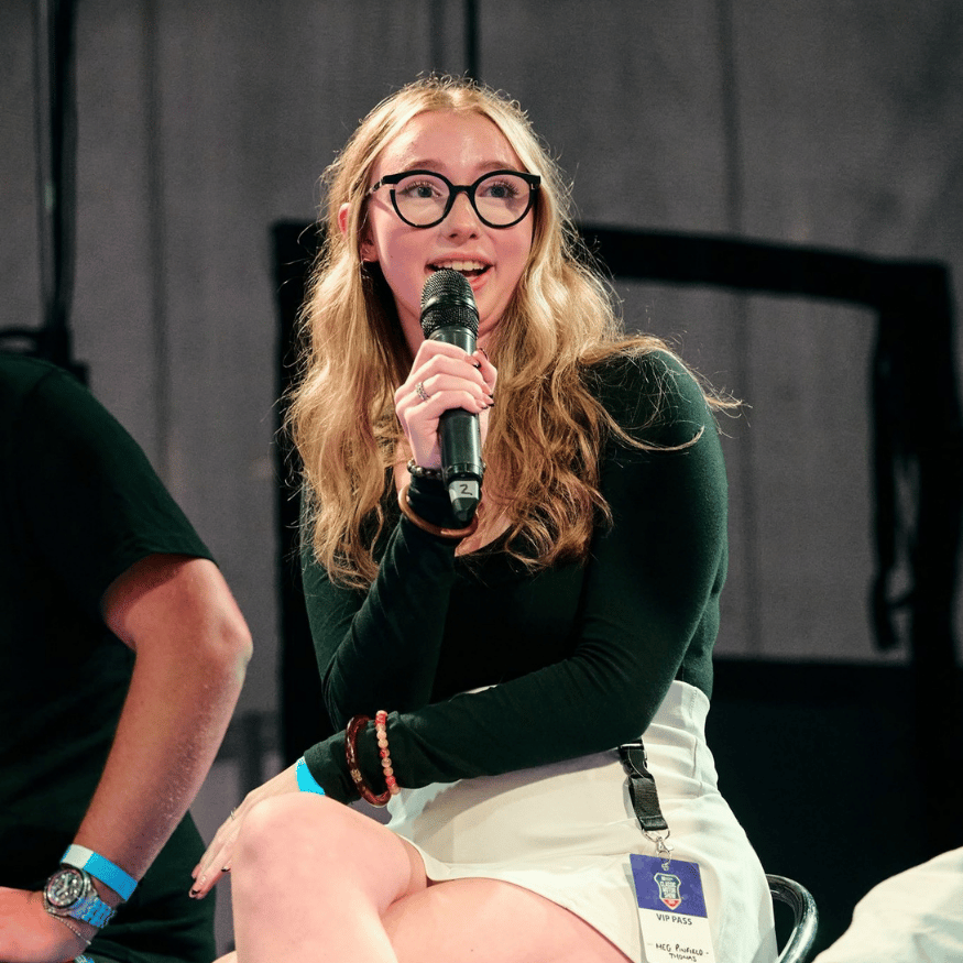 Content creator Meg Pinfield-Thomas from Driven by Meg speaking into a microphone on stage