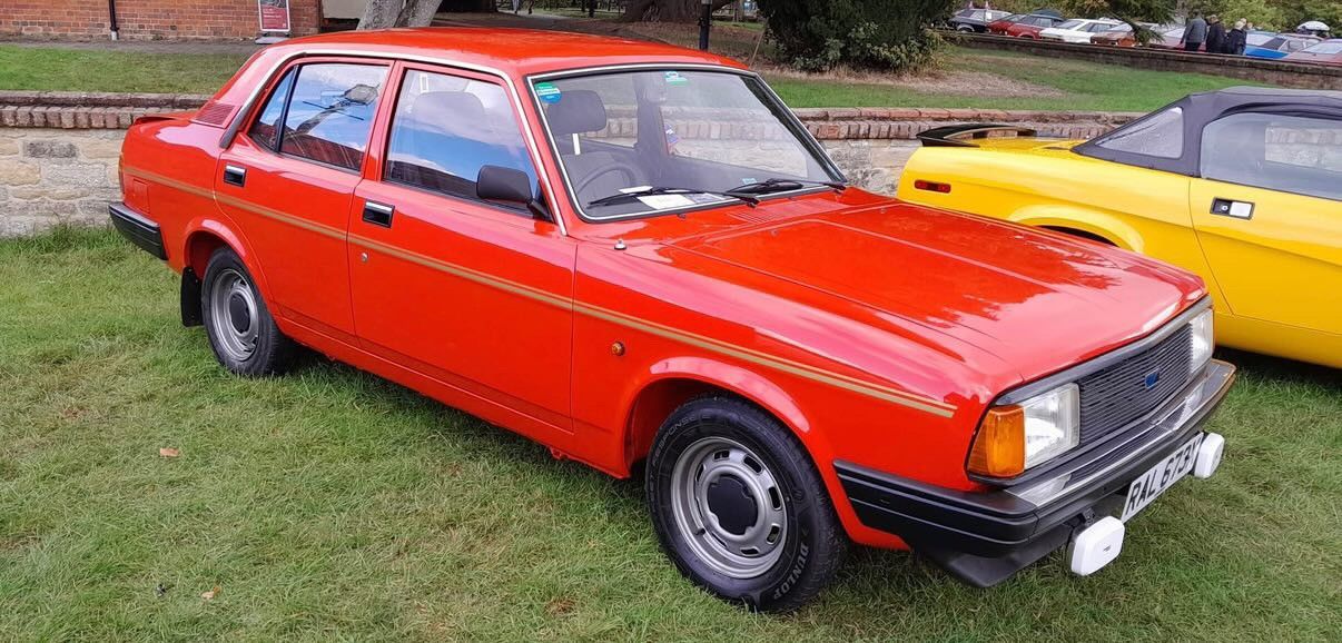 Bright red 1980s Morris Ital saloon with gold pinstripe and black trim.