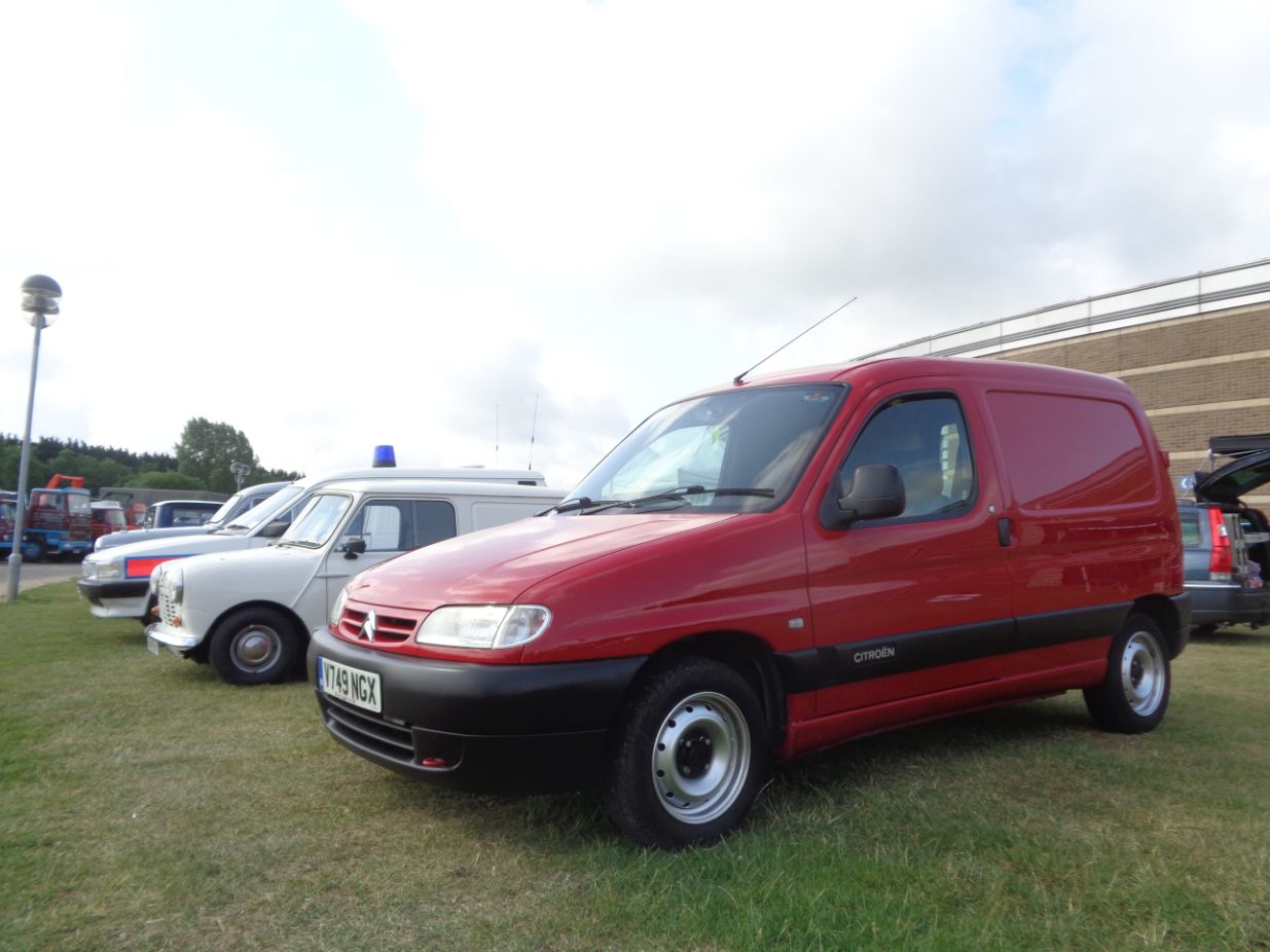 A bright red Citroen Berlingo commercial van, owned by Jason Crawley, with black bumpers, parked on grass at a classic car show next to other older vehicles.