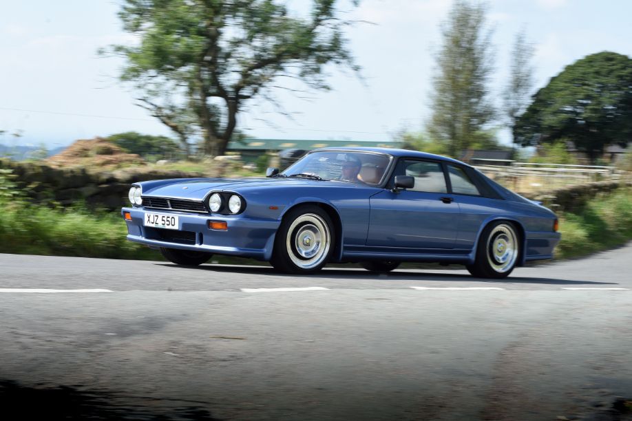 Blue Lister XJ-S vintage sports car in motion on a winding country road.