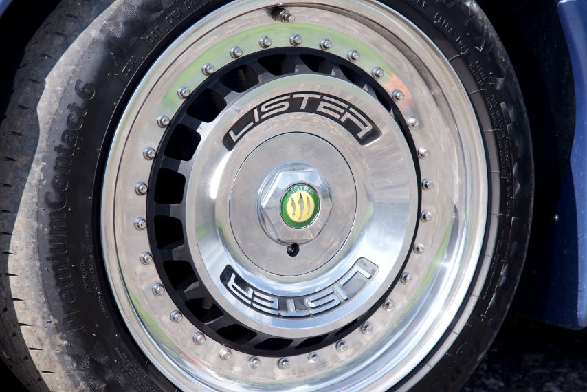 Close-up of the polished wheel and Lister logo on the hubcap of a classic sports car.