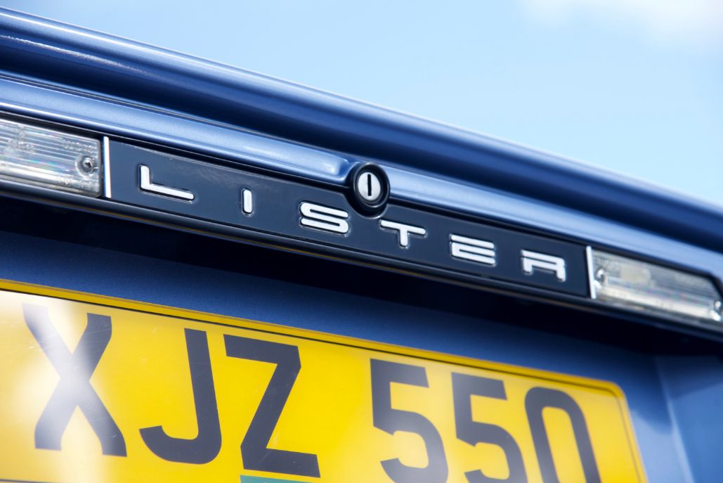 Close-up of the Lister badge on the rear of a classic blue Lister XJ-S sports car.