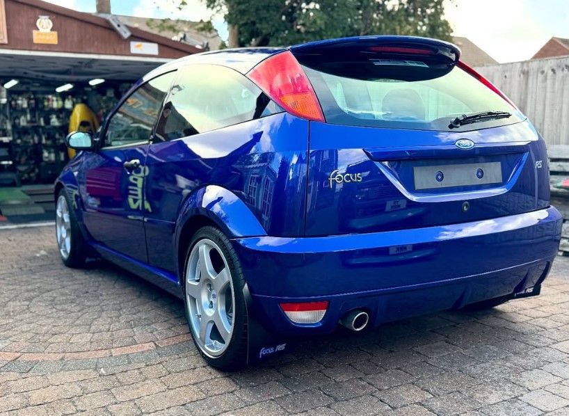 Rear view of a blue Mark 1 Ford Focus RS hot hatch with silver multi-spoke wheels.