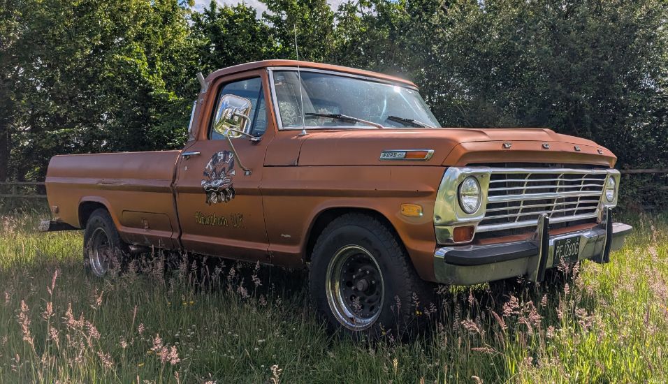 Vintage brown Ford F-250 pickup truck parked in a grassy field, featured on Tasty Classics