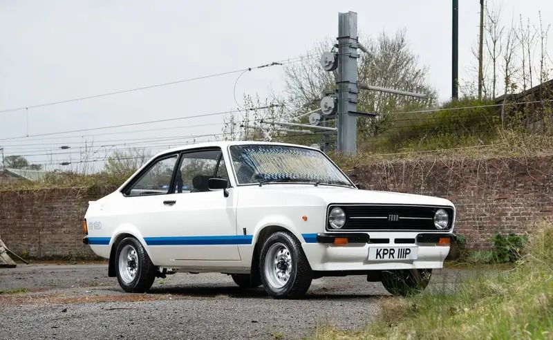 Classic white Ford Escort Mk2 with a blue side stripe.