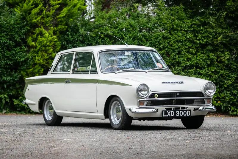 White classic Ford Cortina Mk1 with a green racing stripe on a driveway