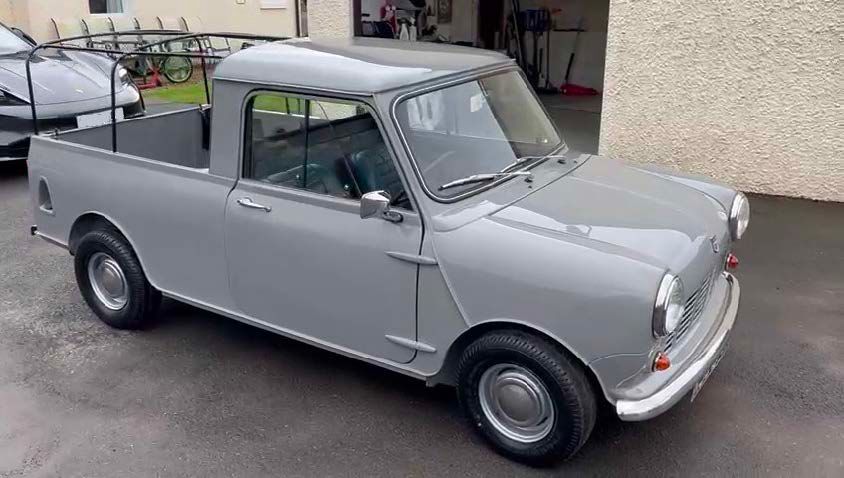 A classic, restored grey Morris Mini 1000 Pickup truck, owned by Richard Holmes, parked on a driveway with a roll bar over the bed.