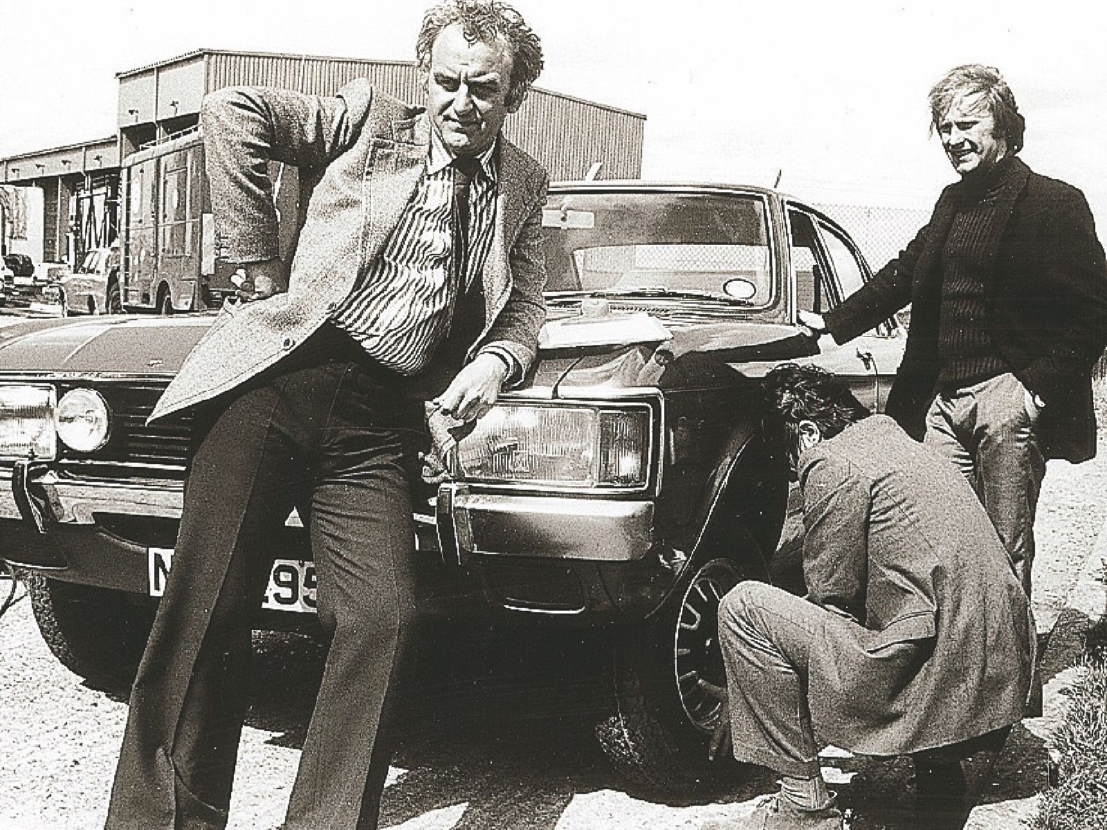 Black and white photo of actors from The Sweeney posing with their classic Ford Consul car.