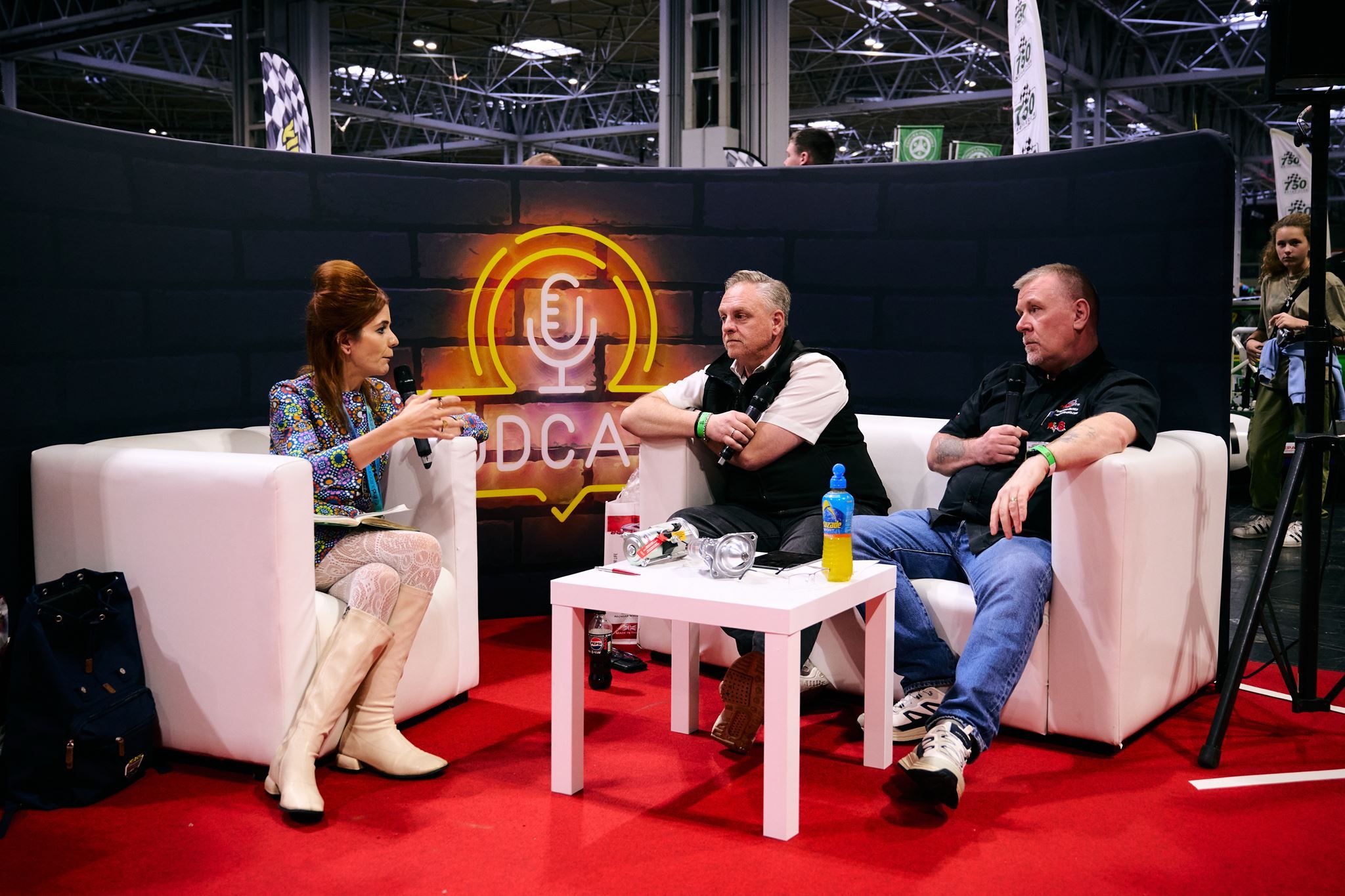 Steph from idriveaclassic and guests discussing cars on stage at the DCA Podcast Lounge during the Classic Motor Show.