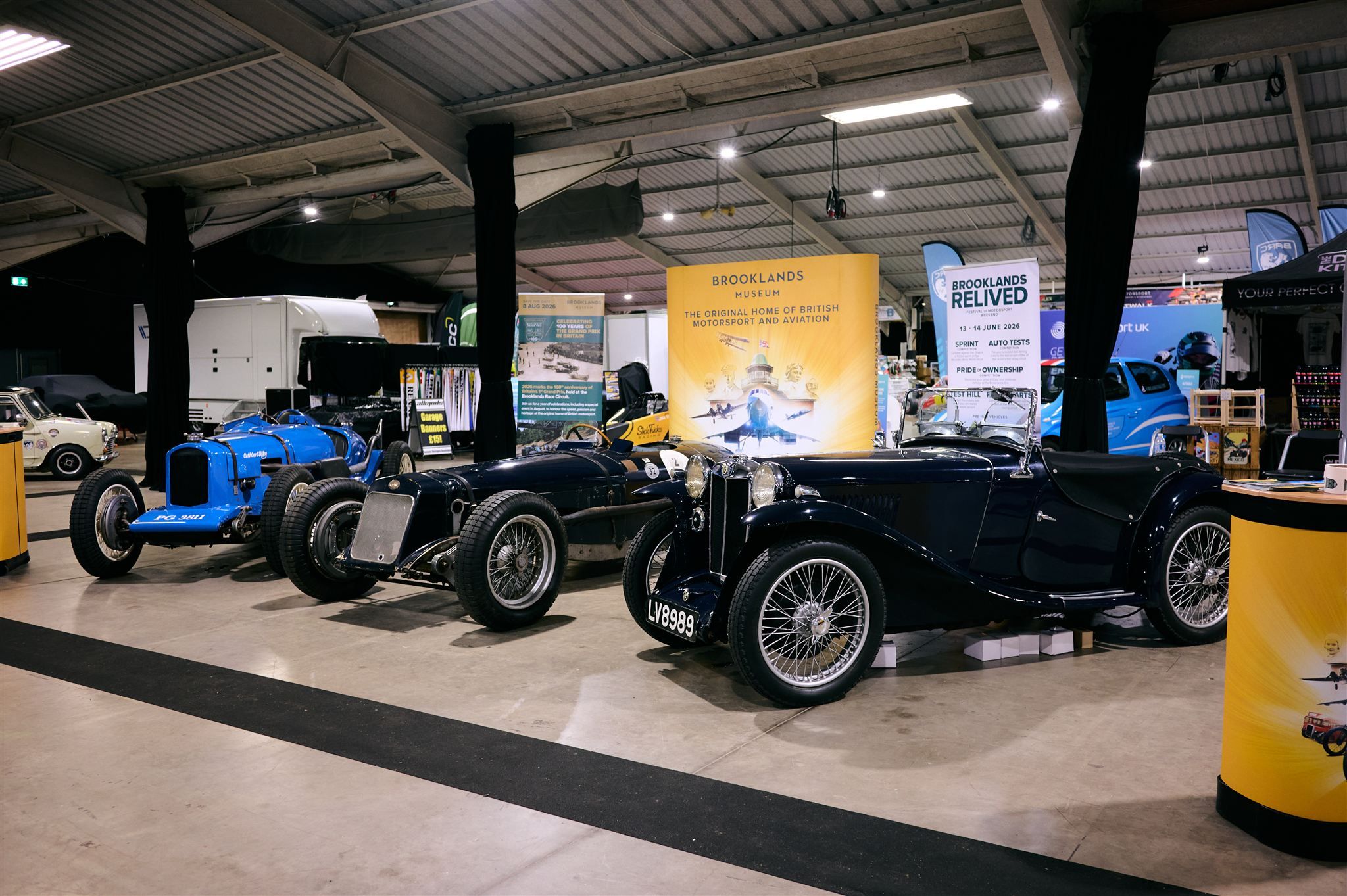 Collection of classic vintage racing cars on display at the Brooklands Museum exhibition stand.