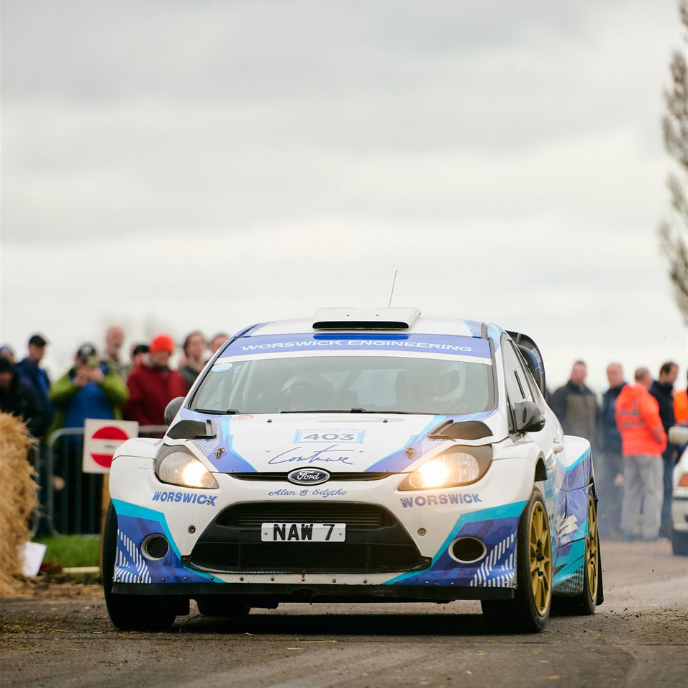 White and blue Ford Fiesta rally car with license plate NAW 7 and Worswick Engineering livery in action.