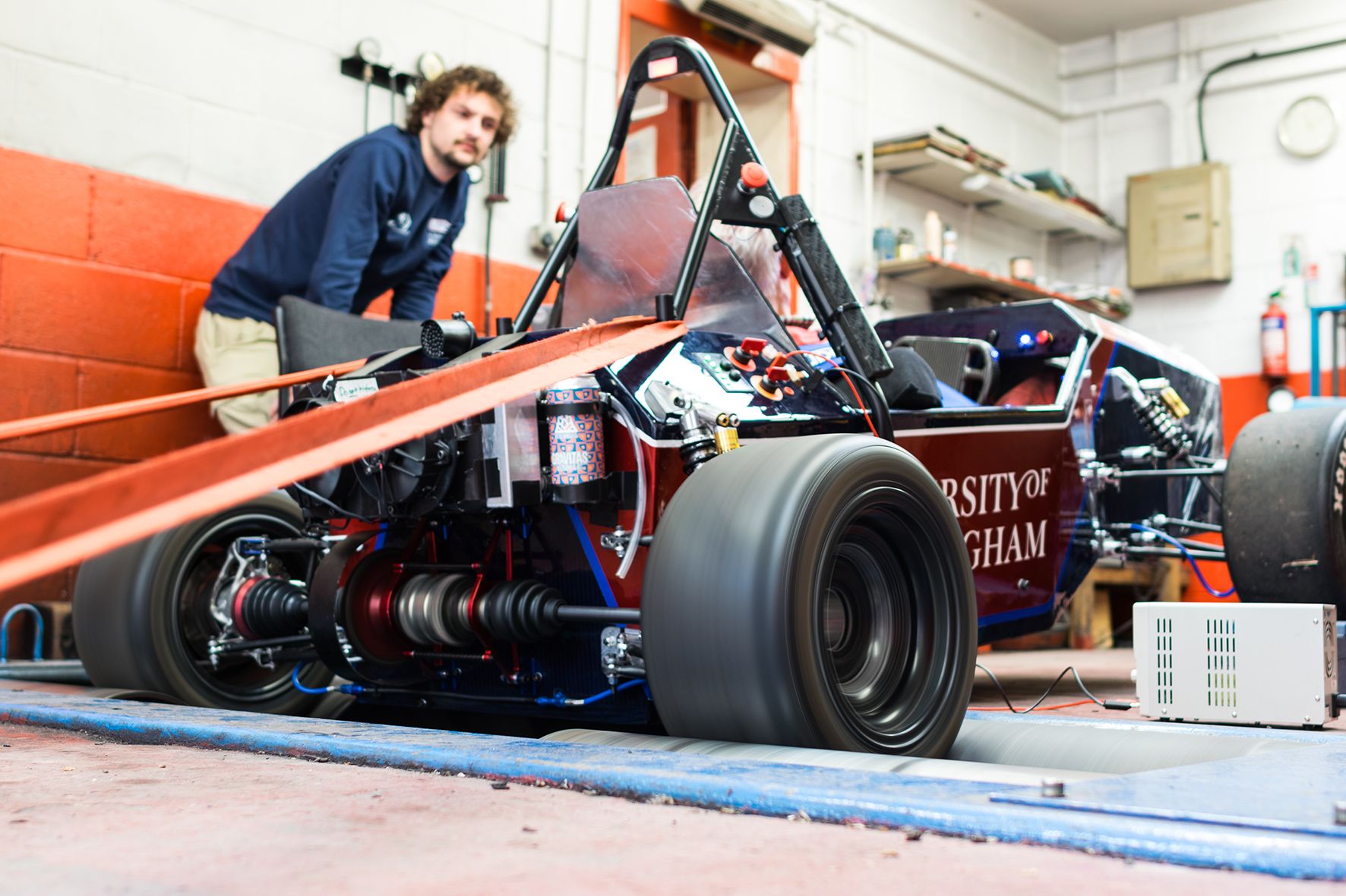 University of Birmingham Formula Student race car undergoing a dynamometer power test in a workshop.