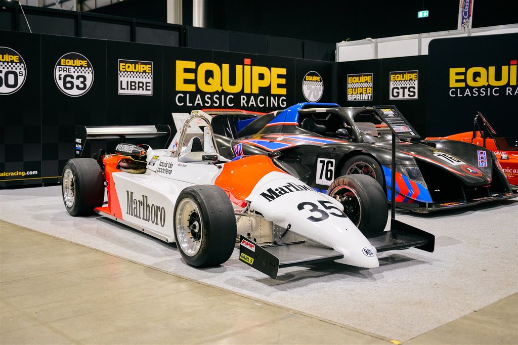 Classic March 761 Formula 1 race car with iconic Marlboro livery, on display with other vintage motorsport and classic cars