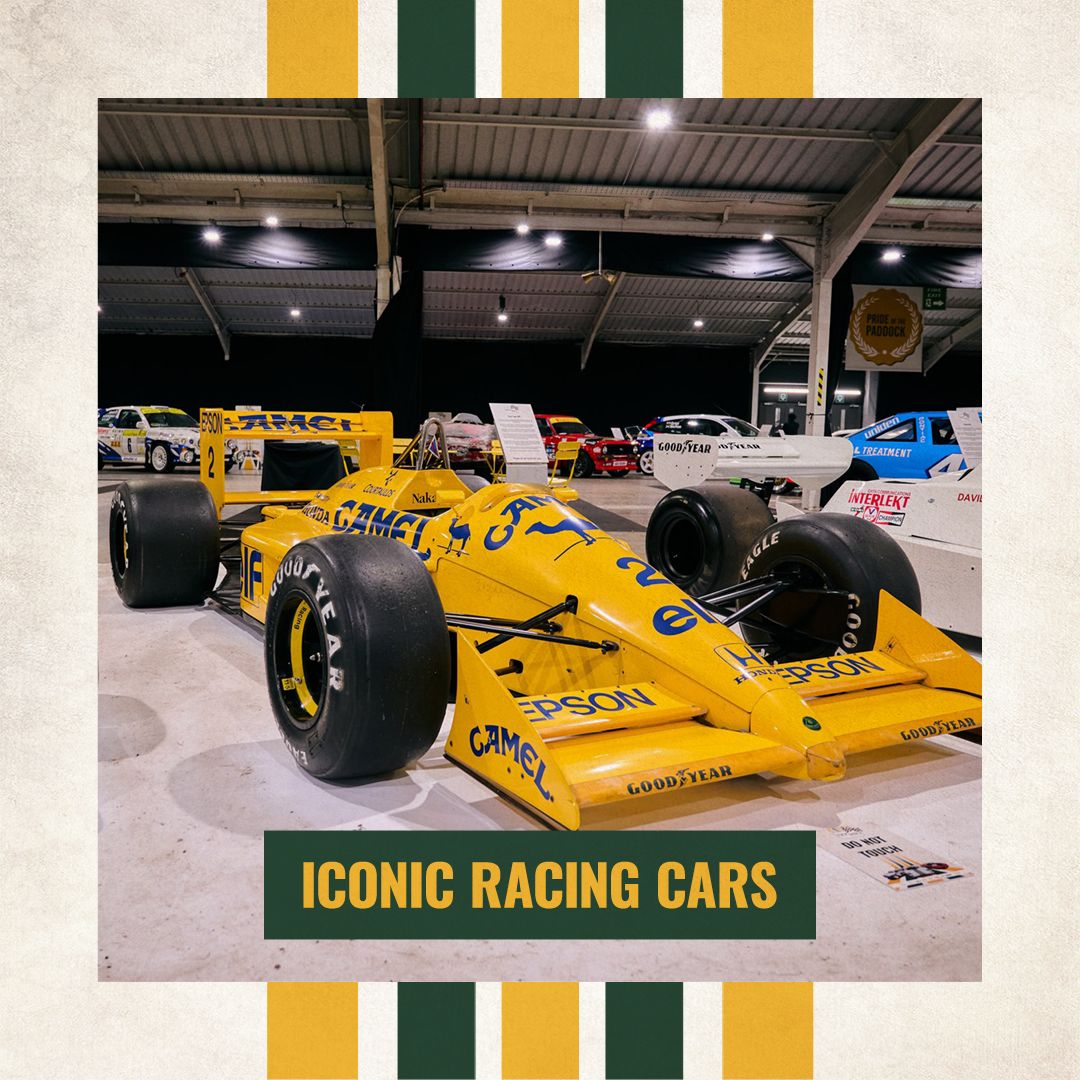 Classic yellow Lotus Formula 1 car with iconic Camel livery on display at an indoor racing car exhibition.
