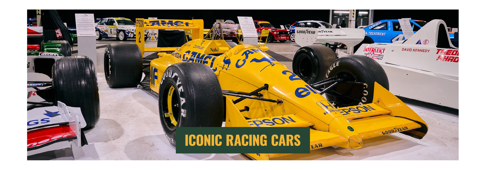 Classic yellow Camel Lotus Honda Formula 1 car on display at an iconic racing cars exhibition.
