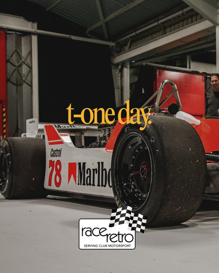 Crowded indoor exhibition hall at the Race Retro motorsport event with yellow 