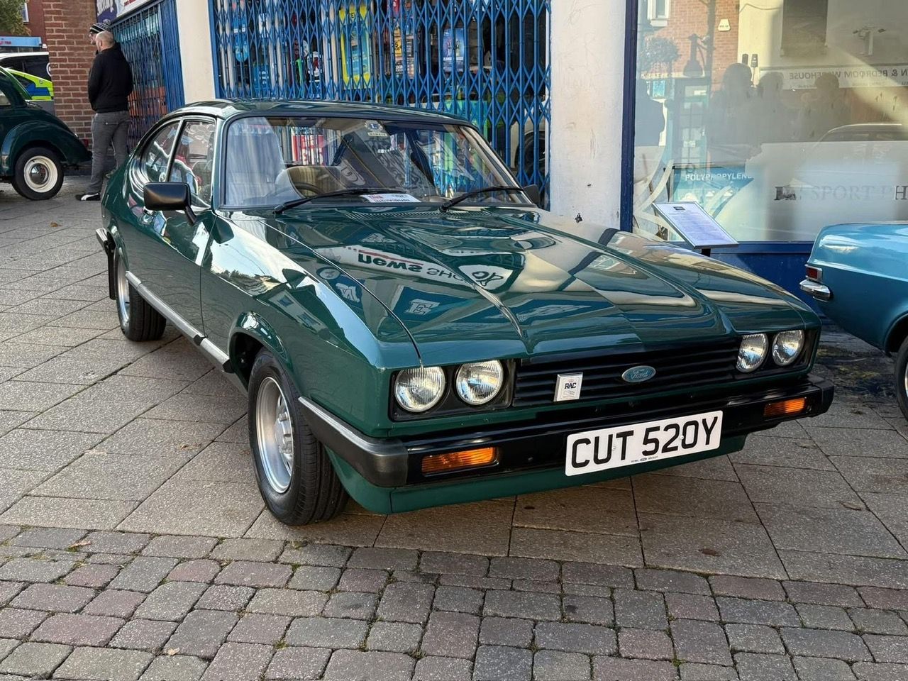 Dark green Ford Capri Mk3 2.8 Injection parked on a paved street at a car show.