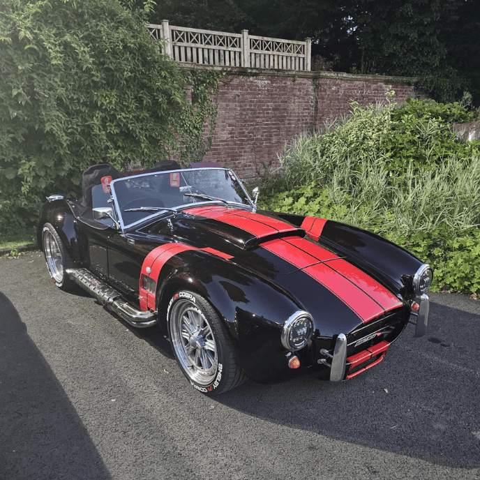 Black AC Cobra replica with red racing stripes, Doug Gray's Pride of Ownership entry at the Restoration Show.