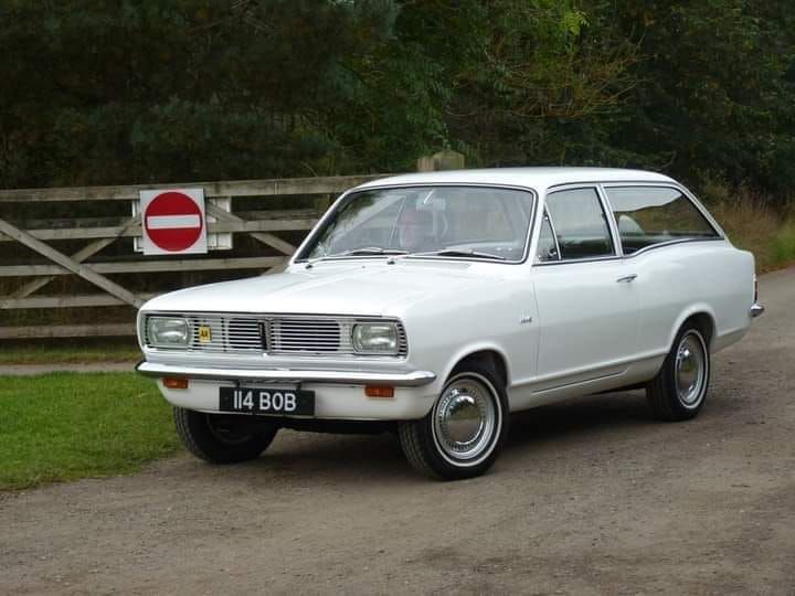 Classic white Vauxhall Viva HC estate with chrome bumpers and a personalized number plate parked on a country road.