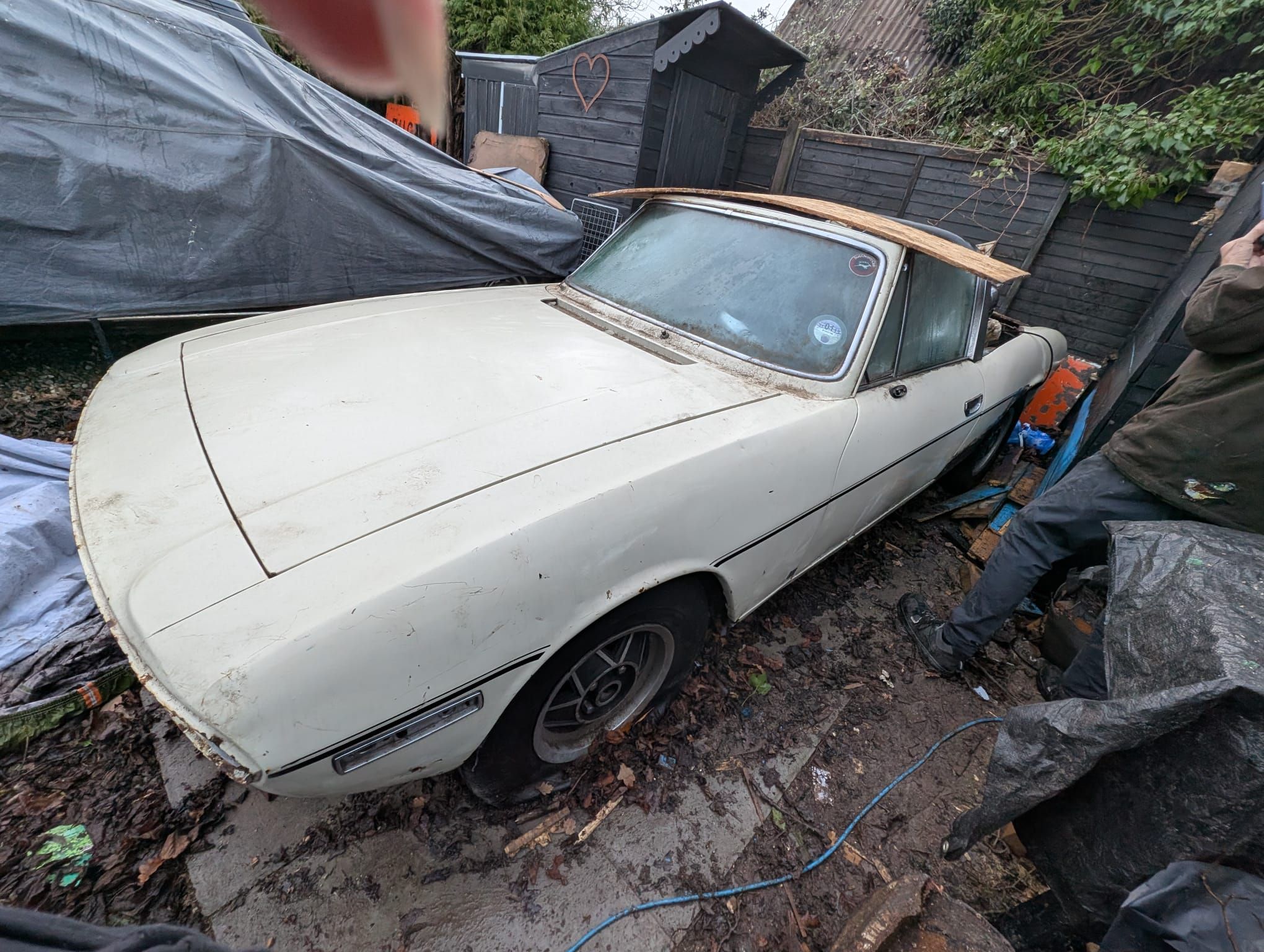White Triumph Stag project with its hood open, undergoing restoration in a professional workshop.