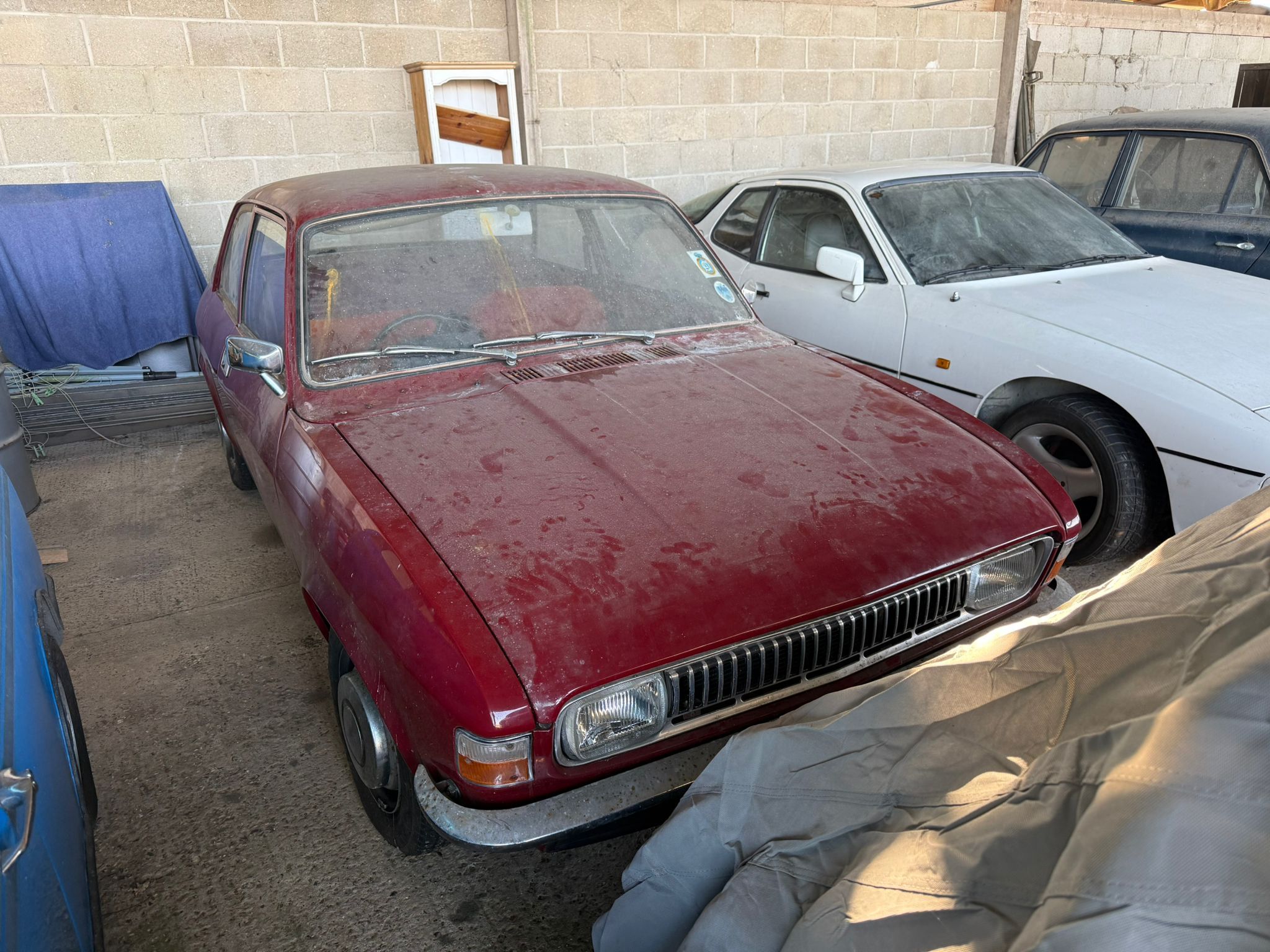 Rare brown Austin Allegro barn find with original hubcaps and aged paintwork in a storage facility.