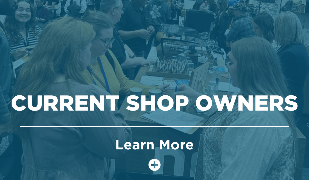 Exhibitor speaking with attendee at table with blue overlay and white text that reads 