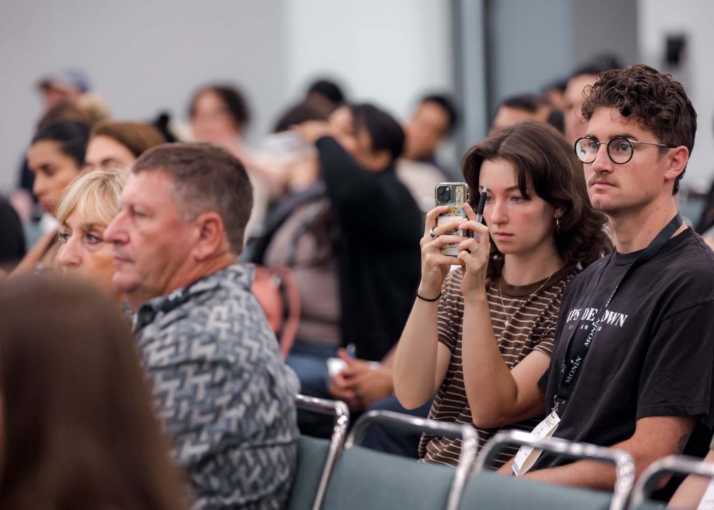 Attendee taking photo of slides during a lecture