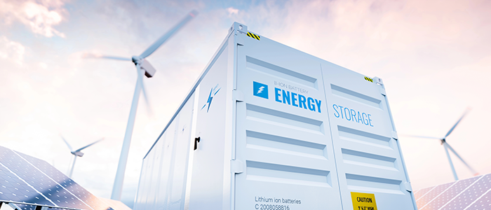 Energy storage battery container with wind turbines and solar panel in the background.