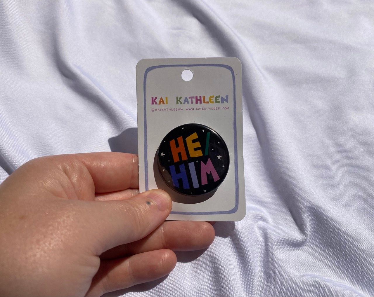 He/him metal badge